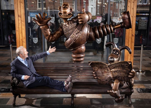 Nick Park sits on the Wallace and Gromit bench statue