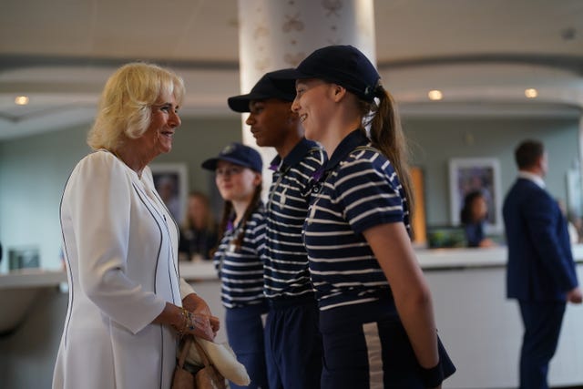 Queen Camilla meeting ball boy and ball girls, Larissa, Sean and Cassie, as she arrives for her visit on day 10 of the 2023 Wimbledon Championships at the All England Lawn Tennis and Croquet Club in Wimbledon