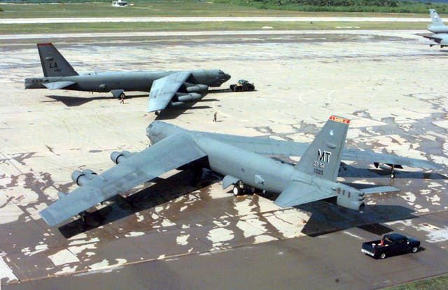 A US Air Force B-52H Stratofortress being towed past another on the flight line at Navy Support Facility Diego Garcia