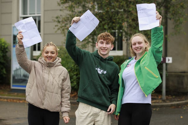 Students Alesha Bideratan, Bailey Finn and Julia Stromczynska hold up their A-level results at Hazelwood Integrated College in Newtonabbey, Belfast