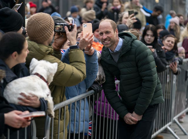 A fan takes a photograph of the Prince of Wales