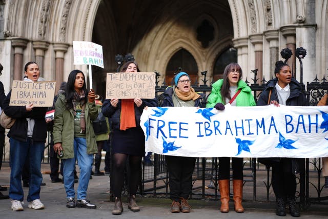 Protesters with banners outside the Royal Courts of Justice in London