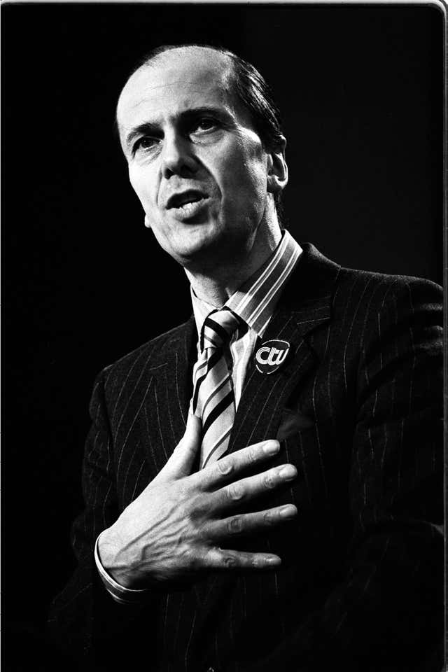 Norman Tebbit with his right hand on his chest