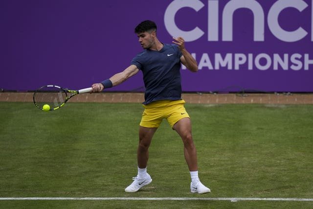 Carlos Alcaraz hits a forehand on his way to victory on the grass at Queen's
