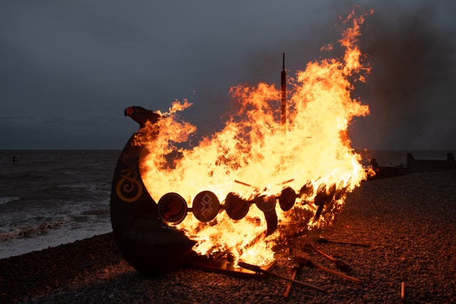 A longboat burns on the beach