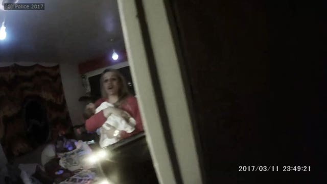 Image from bodycam footage showing Roxanne Davis holding baby Stanley after police were called to her property