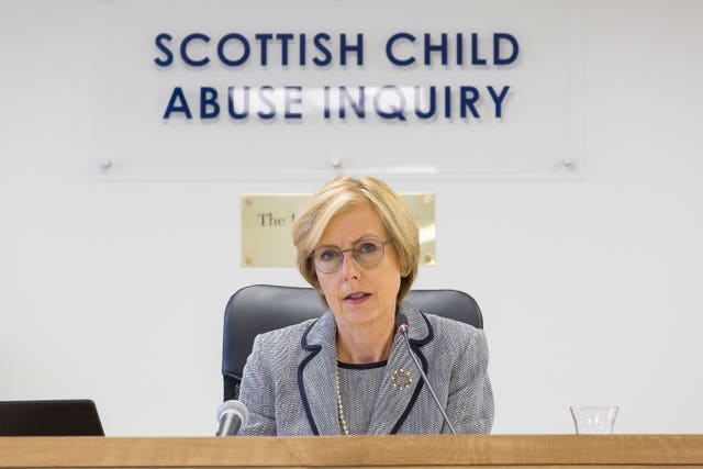 Lady Smith below sign reading 'Scottish Child Abuse Inquiry'