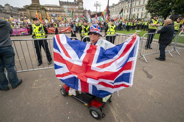 A woman on a mobility scooter holds a Union flag