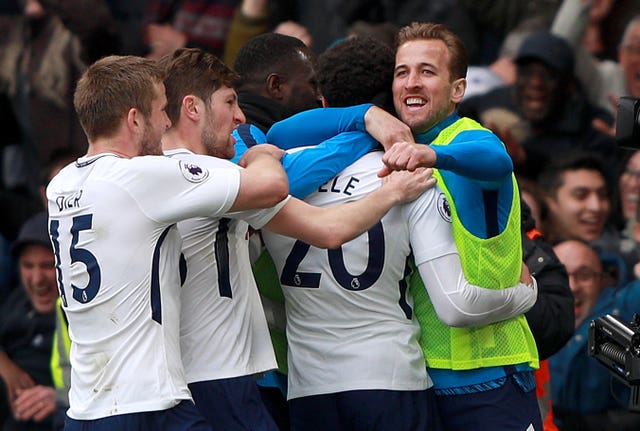 Dele Alli (number20) is mobbed by his team-mates after scoring Tottenham's third goal at Chelsea