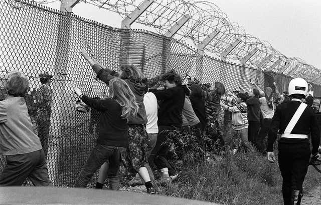 Protesters tugging at the fence at RAF Greenham Common in 1983