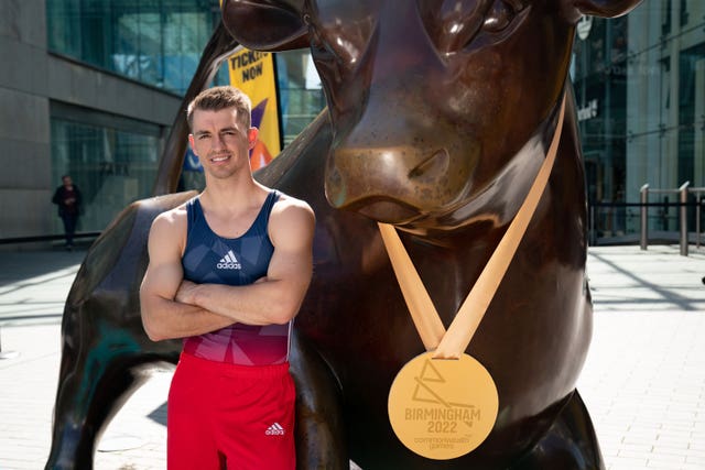 Olympic gymnast Max Whitlock poses in front of a bull statue at the Birmingham Bullring