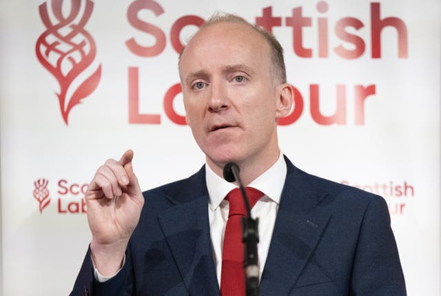 Michael Marra speaking in front of Scottish Labour signage
