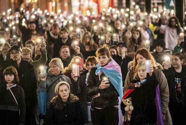 Members of the public hold their phones with the torch function set during a moment of silence as they attend a candle-lit vigil for Brianna