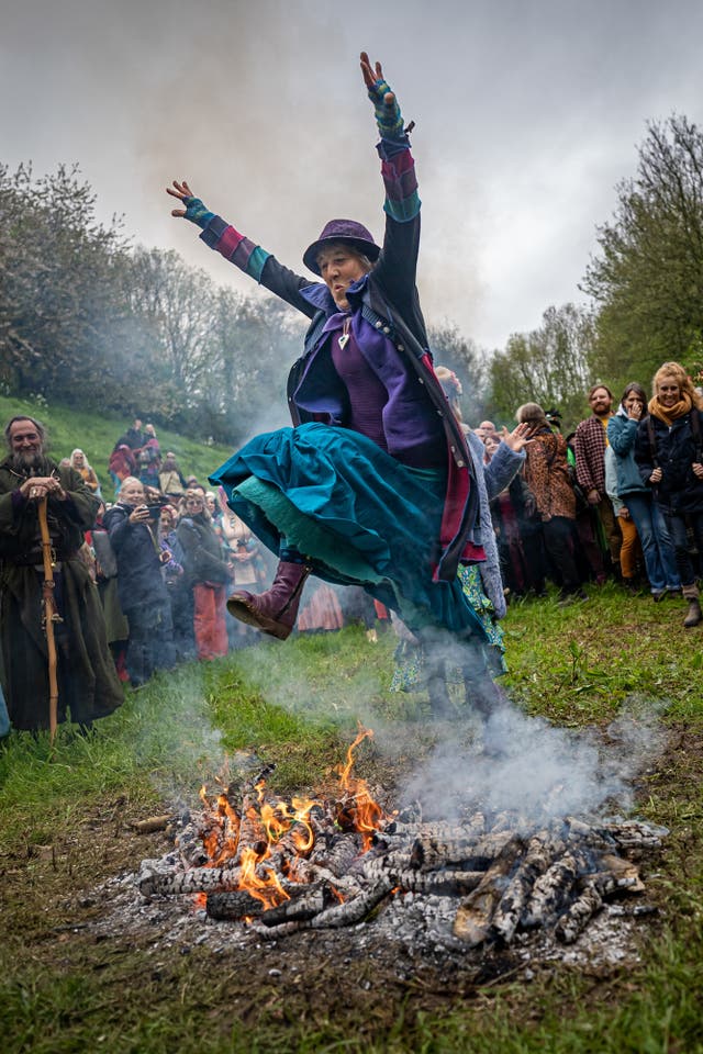 People jump the Beltane bonfire at Chalice Well 