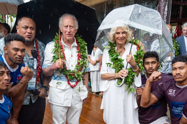 Charles and Camilla with members of the Apia rugby team rugby team during a visit to the Samoan Cultural Village in Apia in October 