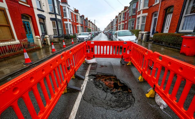 A sink hole that has appeared in Ashbourne Road in Aigburth, Liverpool, as Storm Christoph is set to bring widespread flooding, gales and snow  (Peter Byrne/PA)