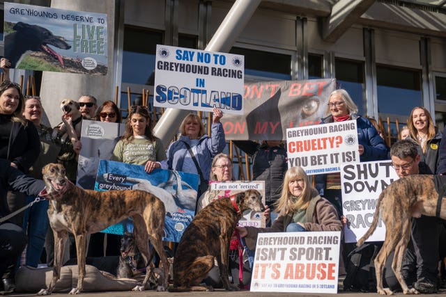 Campaigners who support a greyhound racing ban and greyhounds outside Holyrood