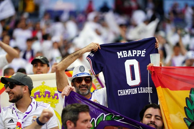 A Real Madrid fan holds up a Kylian Mbappe shirt