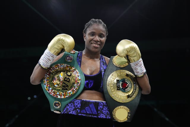 Caroline Dubois celebrates with her title belts after beating Maira Moneo in August