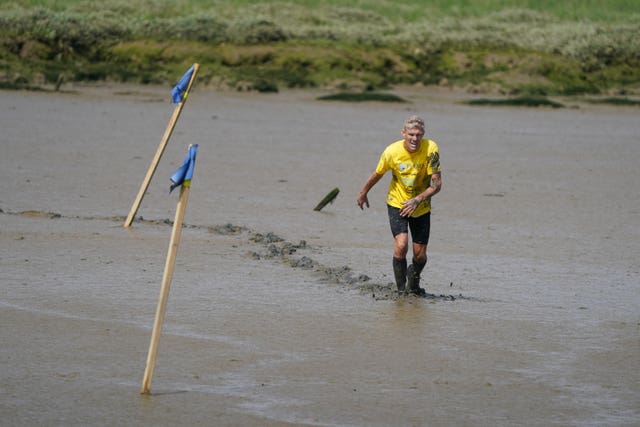 A competitor takes part in the annual Maldon Mud Race, a charity event to race across the bed of the River Blackwater in Maldon, Essex