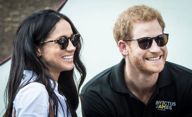 Harry and Meghan grin while wearing sunglasses as they watch the Wheelchair Tennis at the 2017 Invictus Games in Toronto 