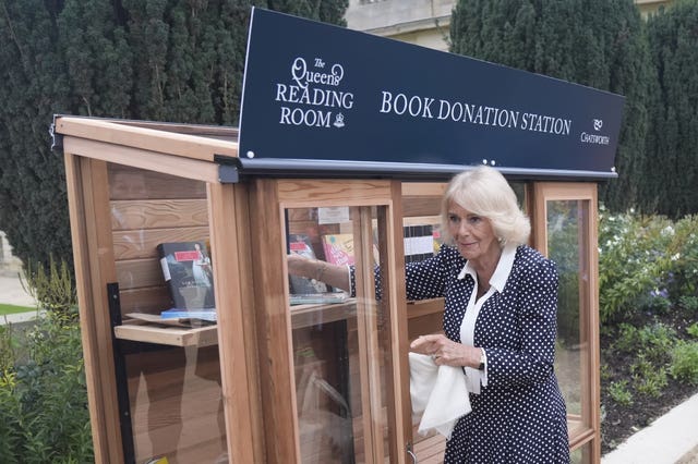 The Queen places books in a donation point for The Queen’s Reading Room at Chatsworth House in Bakewell, Derbyshire 