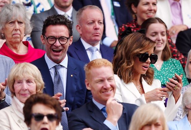 Hugh Jackman smiles in the Royal Box while Kate Beckinsale looks at her phone