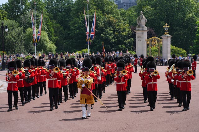 Members of the Band of the Grenadier Guards march outside Buckingham Palace