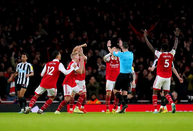 Arsenal players surround referee Andrew Madley 