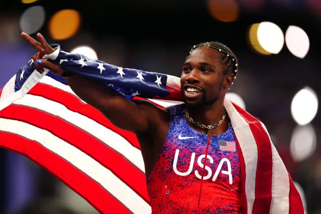 Noah Lyles wrapped in the flag of the United States