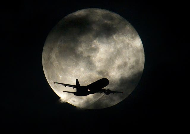 A plane crossing a full moon