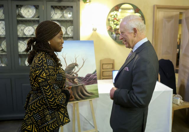 The King laughs with an artist showcasing her work