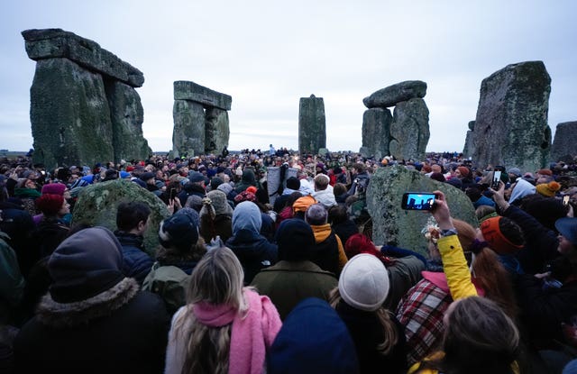 People take part in the winter solstice celebrations during sunrise at Stonehenge in Wiltshire.