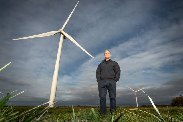 Sir Keir Starmer stands in front of a large wind turbine