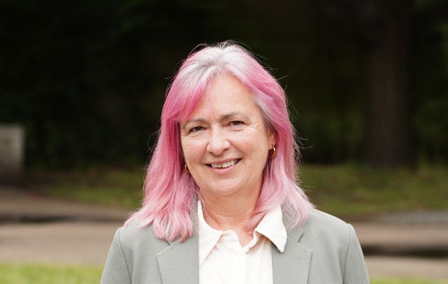 Plaid Cymru MP Liz Saville Roberts, with pink and grey hair and wearing a light-coloured suit jacket and white shirt, smiling at the camera