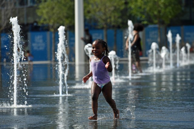 Girl plays in water fountains