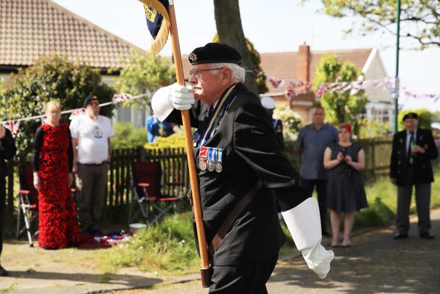 Local Royal British Legion branch chairman Eric Howden, 75, carries his standard in Redcar, in North Yorkshire, where local residents held a two-minute silence to mark the 75th anniversary of VE Day