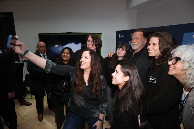 Arnold Schwarzenegger poses for a picture with students from the Ulster Screen Academy after receiving his honorary doctorate presented to him by the Ulster University in Belfast