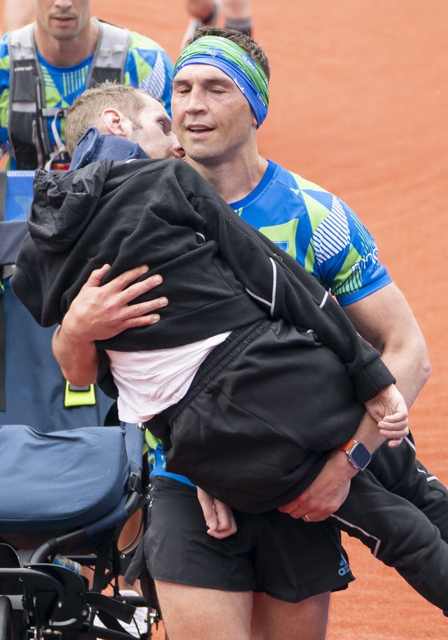 Kevin Sinfield carries his friend Rob Burrow over the finish line at the Rob Burrow Leeds Marathon in May 2023 