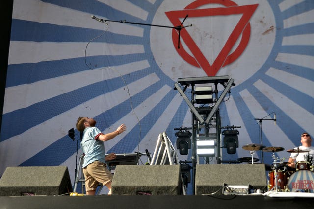 Enter Shikari performing on stage, with Rou Reynolds throwing his microphone into the air