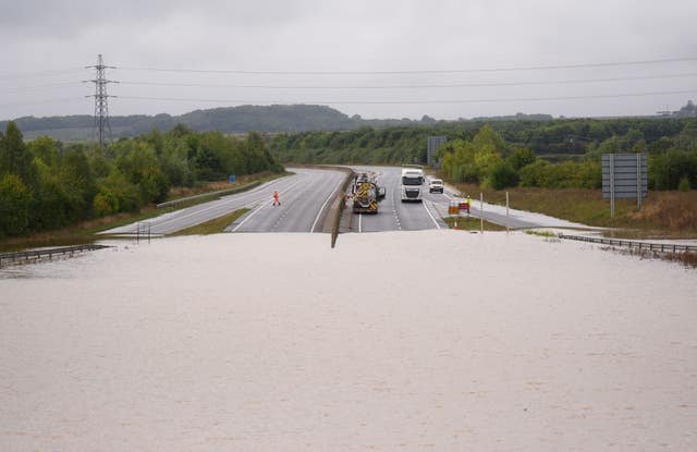 A flooded road with traffic in the distance