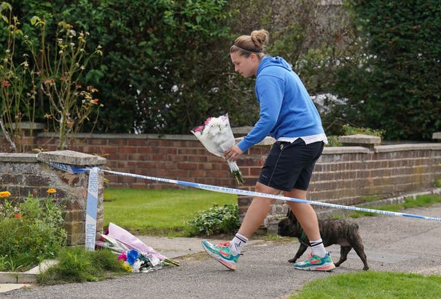 A person leaves flowers outside a property on Hammond Road in Woking, Surrey, where Sara Sharif was found dead 