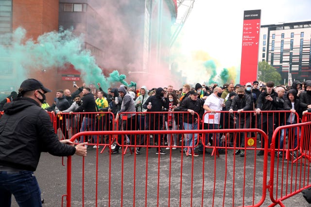 Fans move barriers outside the ground as they let off flares 
