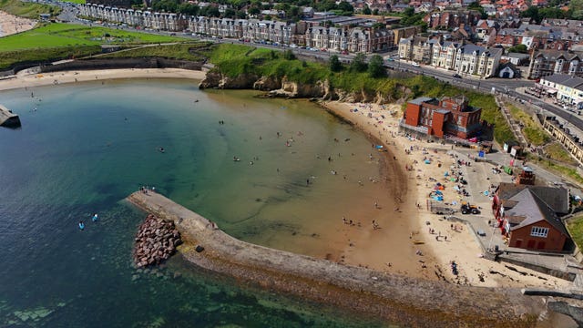 Aerial view of Cullercoats Bay including the north pier and sandy beach on North Tyneside