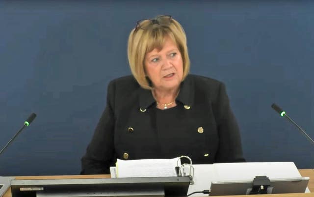 Baroness Heather Hallett, a blonde woman, sits in front of a blue background