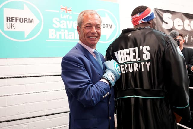 Nigel Farage, wearing a blue boxing glove, with former boxer Derek Chisora