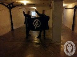Mark Jones and another man giving a Nazi salute in the execution room at the site of the Buchenwald nazi death camp in Germany 