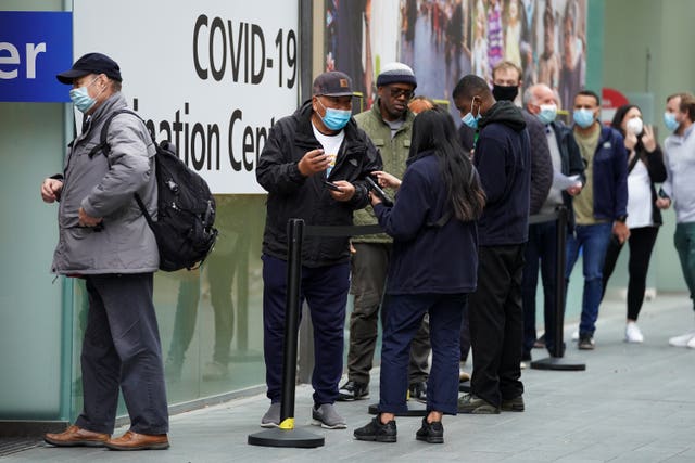 People queue to receive a Covid-19 jab at the pop-up vaccination centre at Westfield Stratford City shopping centre