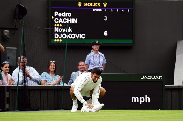 Novak Djokovic wipes the floor with a towel