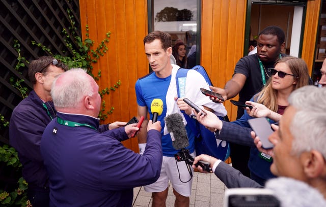 Andy Murray talks while surrounded by journalists